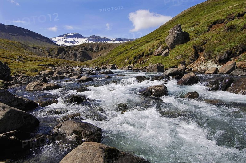 Fast-flowing mountain stream coming down from the hills above Faskrudsfjordur, in the East Fjords region of eastern Iceland