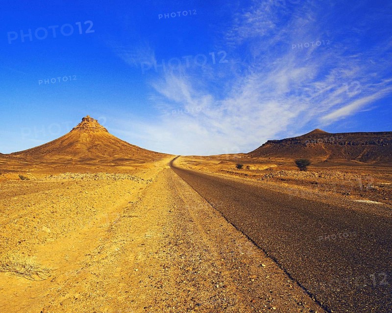 Lonely road penetrating sandy rocky hills in the eastern Atlas Mountains, southern Morocco