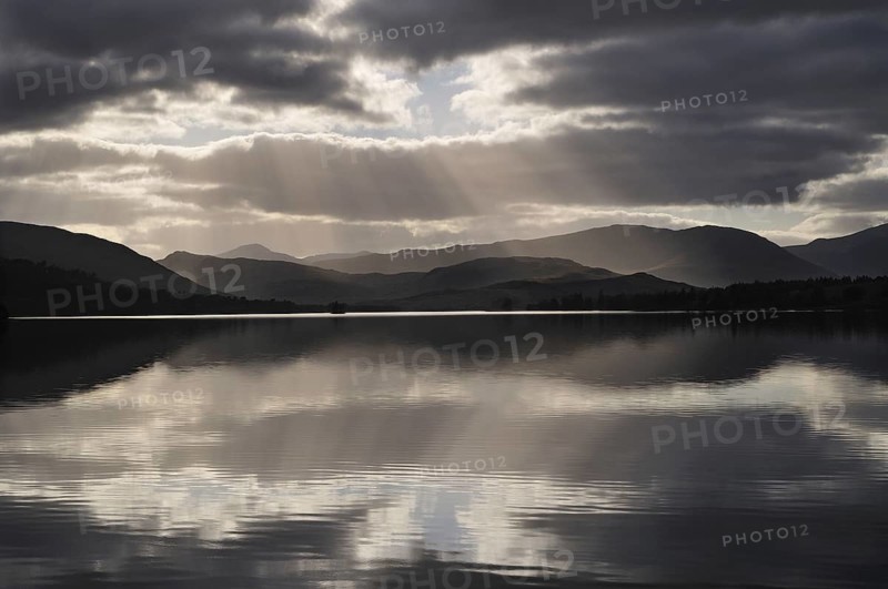 Sunrays and backlit clouds over Loch Tulla, Rannoch Moor, Scottish Highlands, UK