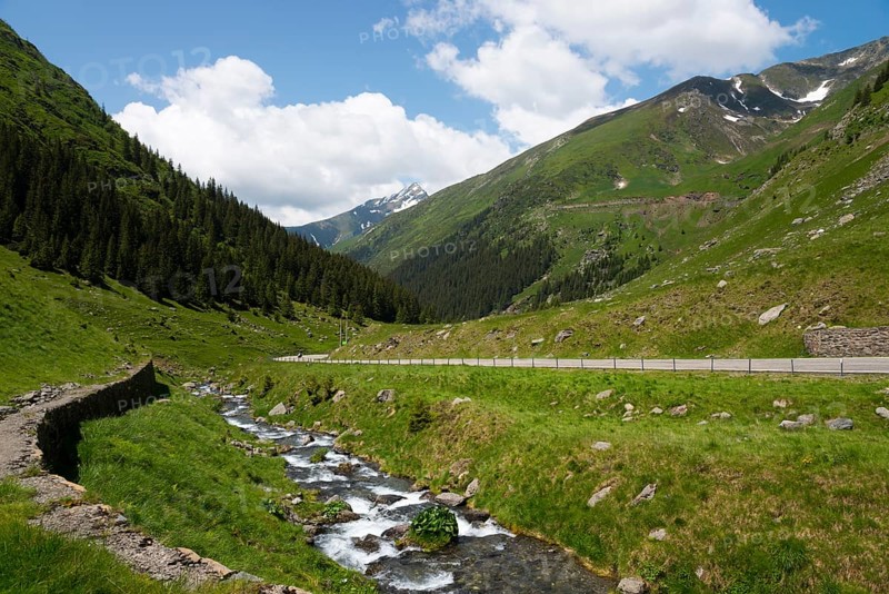 A mountain stream flows beside a road through an idyllic landscape, Capra River, mountain road, Transfogarasan High Road, Transfagarasan, TransfagaraÈ™an, FagaraÈ™ Mountains, Fagaras, Transylvania, Transylvania, Transylvania, Ardeal, Transilvania, Carpathians, Romania, Europe