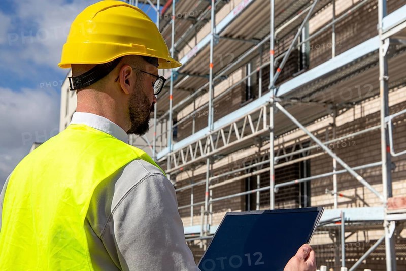 Symbolic image: Architect in front of an apartment block under construction