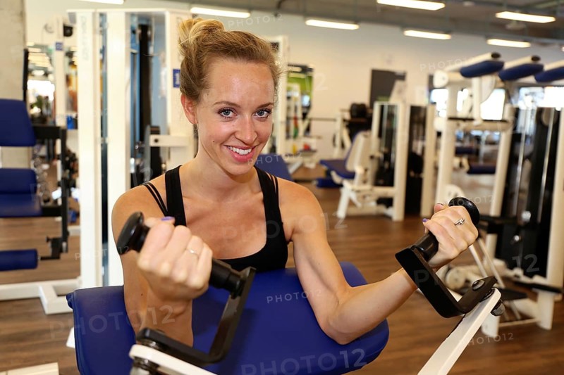 Young woman training on equipment in the gym