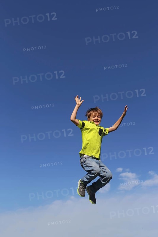 Symbolic image: Boy jumping into the air, blue sky in the background