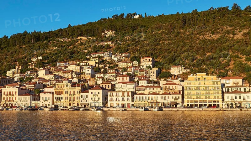 Dense development along the coast, glowing in the light of the morning sun, Gythio, Mani, Peloponnese, Greece, Europe