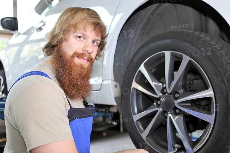 Symbolic image: Car workshop: Car mechatronics technician servicing tyres