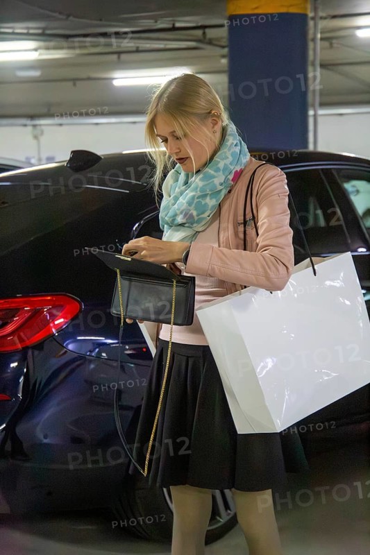 Elegant young woman in a car park