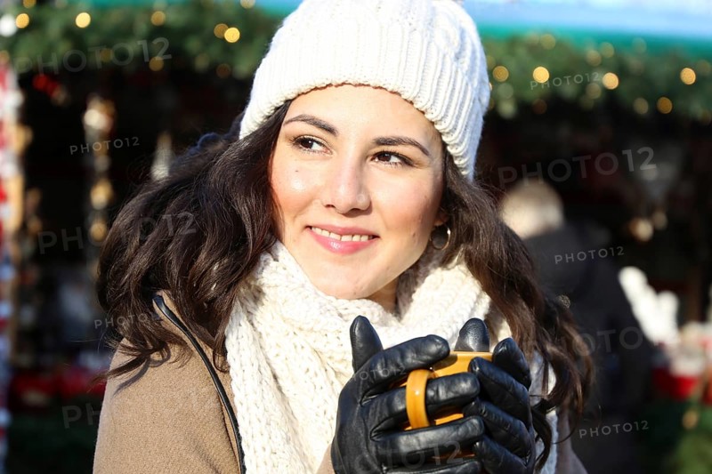 Symbolic image: Cheerful young woman at a Christmas market