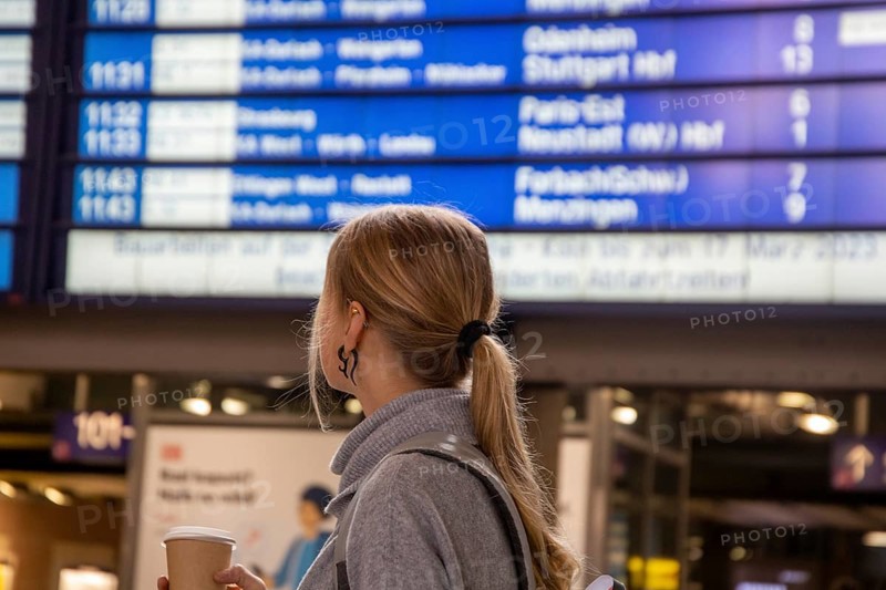 Young woman looking at the scoreboard in a railway station