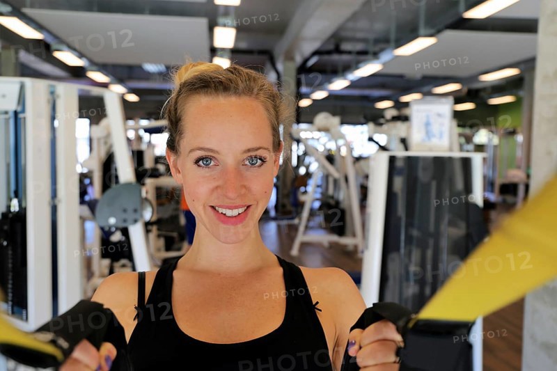 Young woman doing TRX training in the gym, (Neuhofen, Rhineland-Palatinate)
