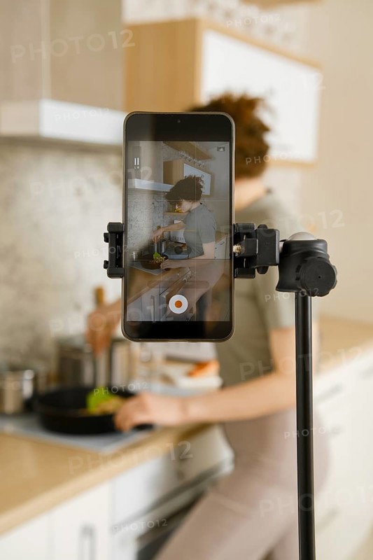 Food vlogger recording video in her kitchen, making step by step tutorial of a receipt