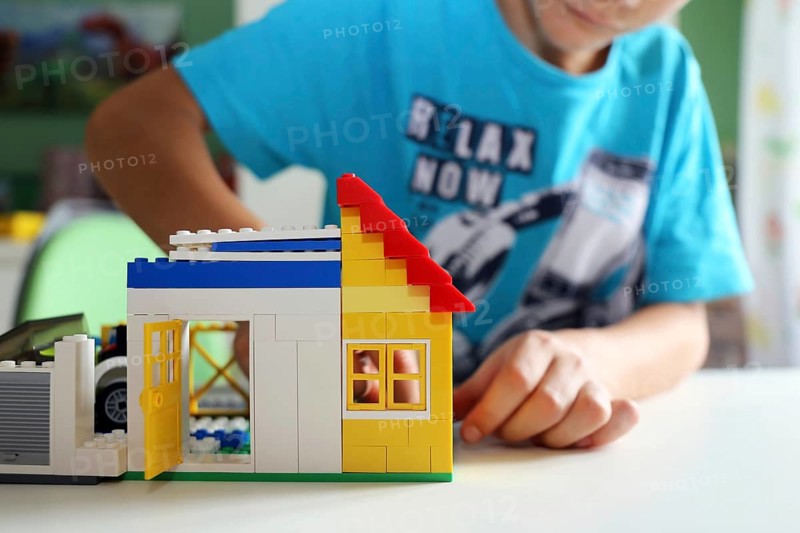 Boy builds a house with building blocks