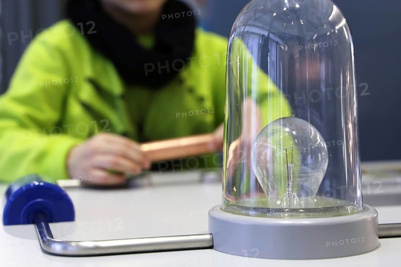 Child conducting a physics experiment with a simple circuit