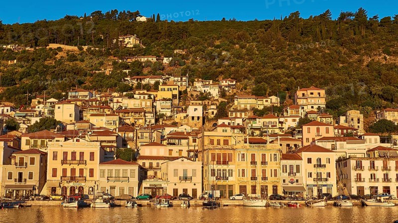 The morning light illuminates the lively coastal panorama and the busy harbour, Gythio, Mani, Peloponnese, Greece, Europe