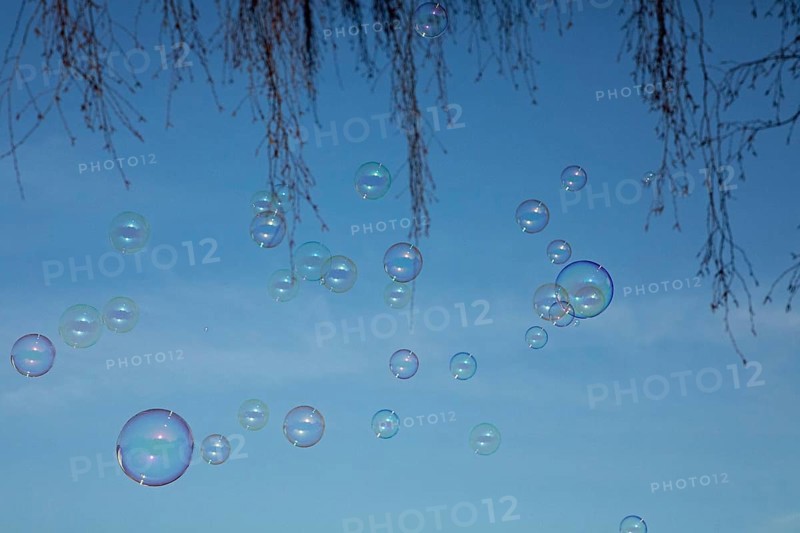 Soap bubbles multicoloured film of soapy water next to each other in front of a blue sky