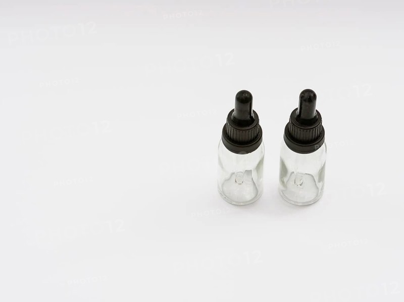 Two glass eye dropper bottles isolated on white background