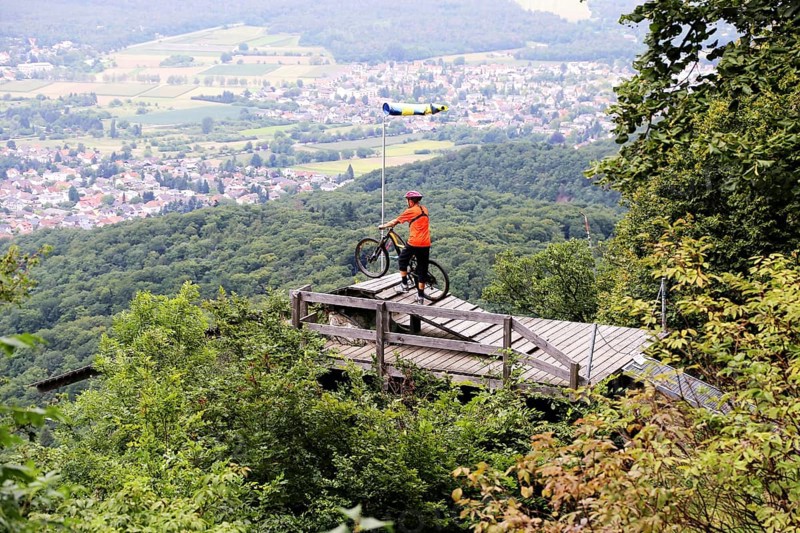 Mountain biker stands on the launch ramp for hang-gliders below the Melibokus and looks out over the Rhine plain