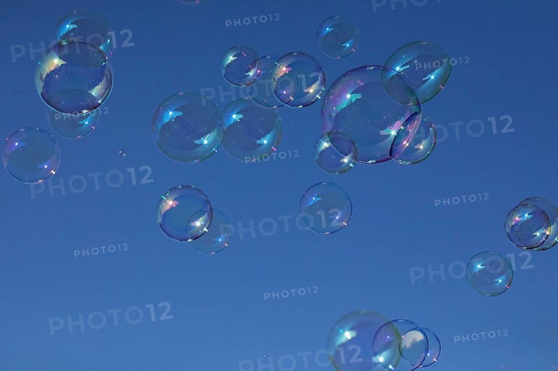 Soap bubbles multicoloured film of soapy water next to each other in front of a blue sky