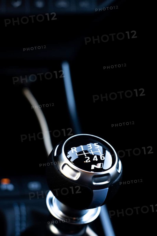 Vertical photography of the manual gearshift lever of a luxury car with dark interior