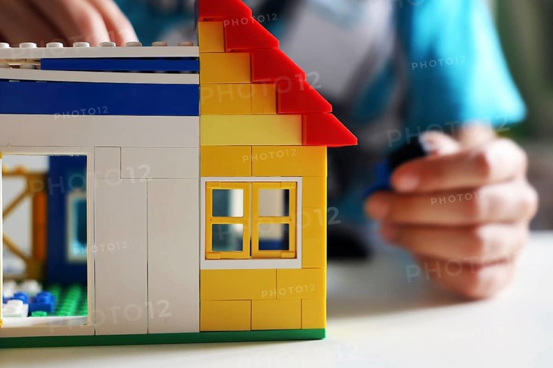 Boy builds a house with building blocks