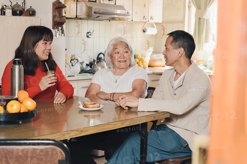 Japanese Family talking and drinking yerba mate at home. Argentinian family of Japanese descent sharing mate at home