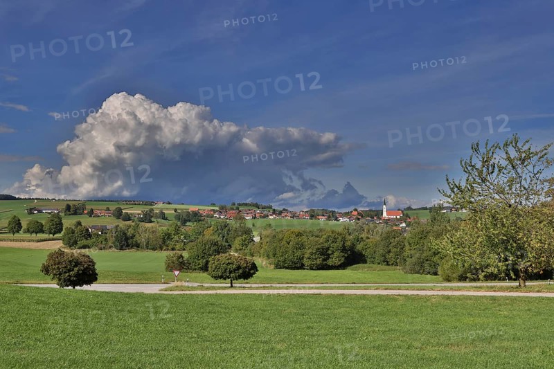 Threatening thundercloud over a sunny, hilly landscape with a village in the foothills of the Alps, Kirchdorf near Haag, Upper Bavaria, Bavaria, Germany, Europe
