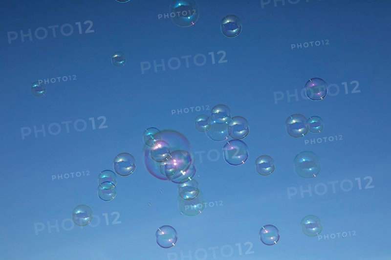 Soap bubbles multicoloured film of soapy water next to each other in front of a blue sky