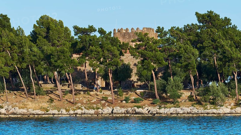 Old stone castle surrounded by pine trees on the Mediterranean coast, Gythio, Mani, Peloponnese, Greece, Europe