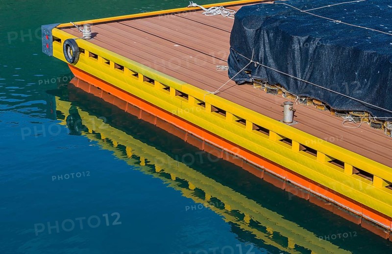 Round lobster traps under black mesh stacked on floating dock at ocean port in South Korea
