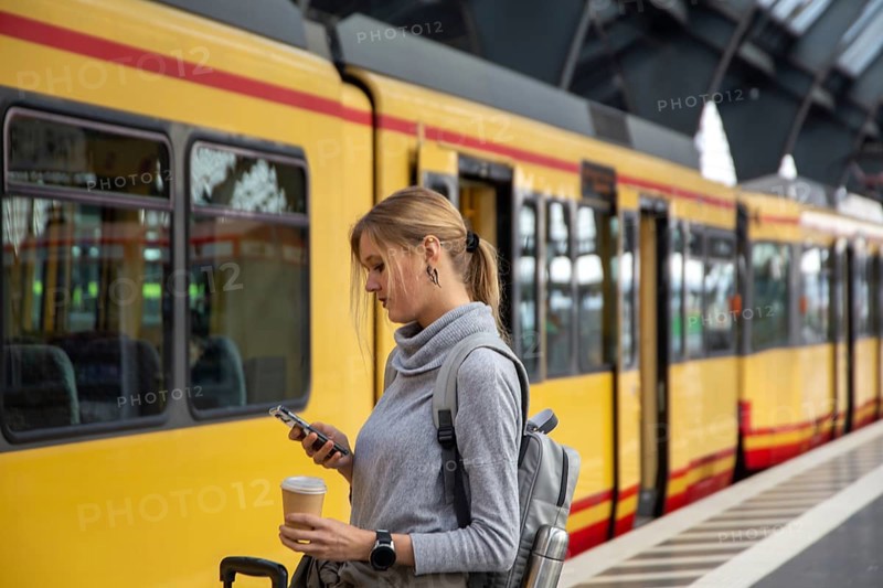 Close-up of a young woman in front of a train at the station