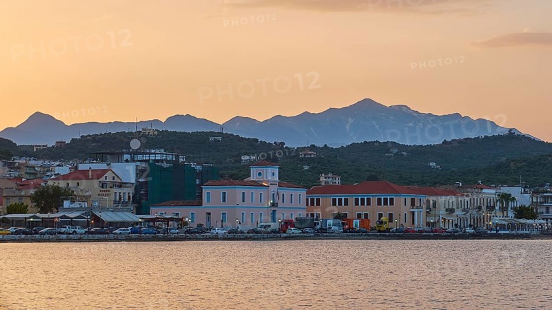 Coastline with buildings and mountains during a colourful sunset, Snow-covered Taygetos Mountains, Taygetos, Gythio, Mani, Peloponnese, Greece, Europe