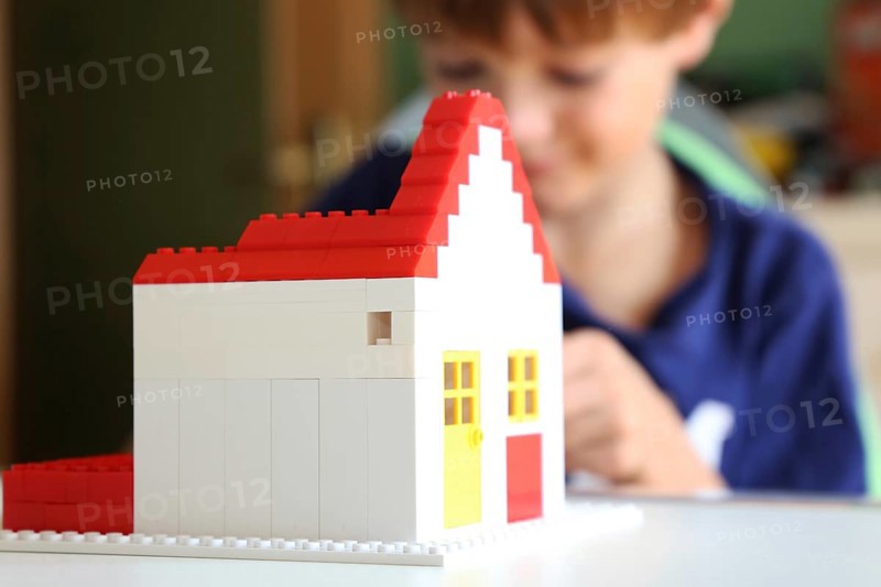 Symbolic image: Boy builds a house with building blocks