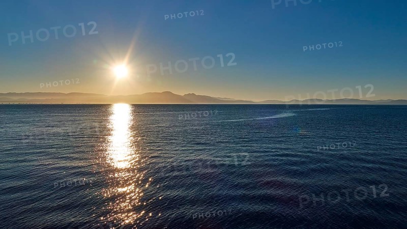 Sunrise over the sea with calm waves and clear sky, Gythio, Mani, Peloponnese, Greece, Europe