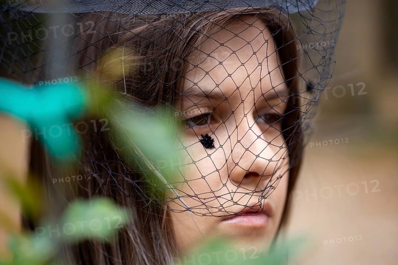 Close-up of a grieving young woman with a mourning veil (symbolic image)