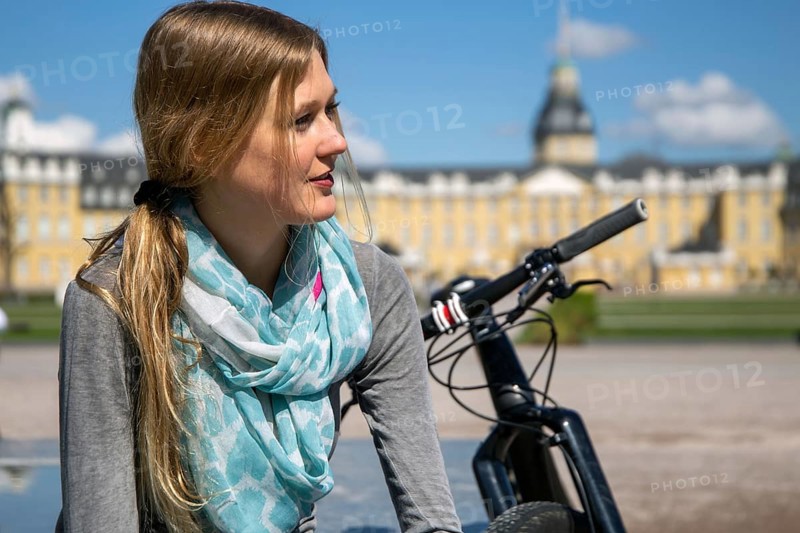 Young woman with bicycle enjoying the spring weather in Karlsruhe Palace Gardens (symbolic image)