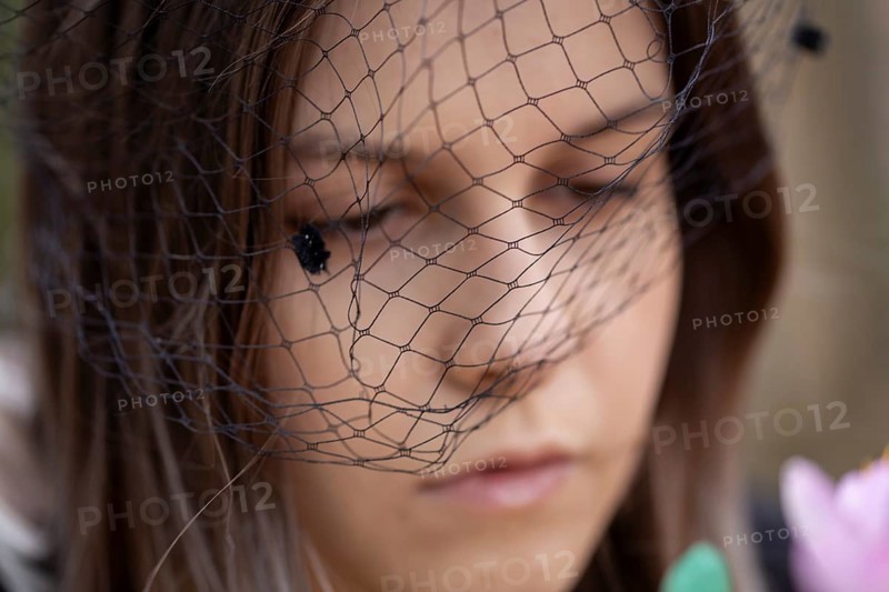 Close-up of a grieving young woman with a mourning veil (symbolic image)