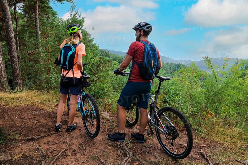 A mountain biking couple taking a break at a beautiful viewpoint in the Palatinate Forest