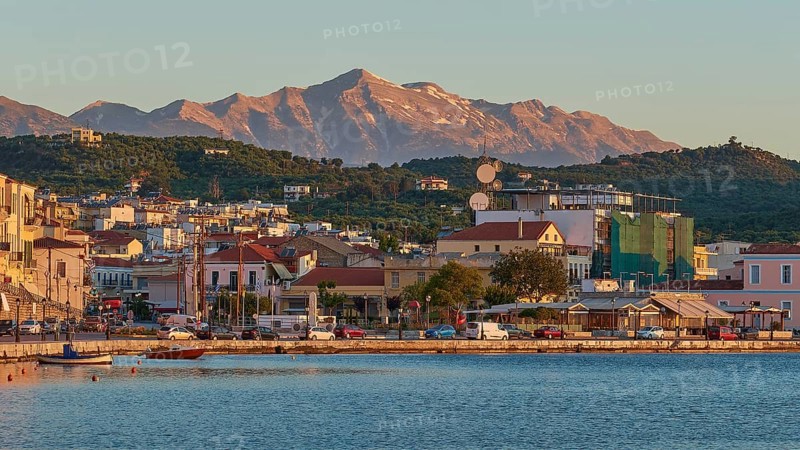 Evening sun illuminates a picturesque harbour town by the sea with mountains in the background, Taygetos Mountains, Taygetos, Gythio, Mani, Peloponnese, Greece, Europe