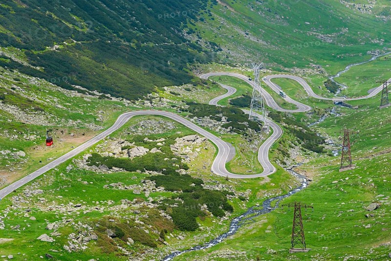 A serpentine road winds through the mountain landscape with views of electricity pylons, Balea River, mountain road, Transfogarasan High Road, Transfagarasan, TransfagaraÈ™an, FagaraÈ™ Mountains, Fagaras, Transylvania, Transylvania, Transylvania, Ardeal, Transylvania, Carpathians, Romania, Europe