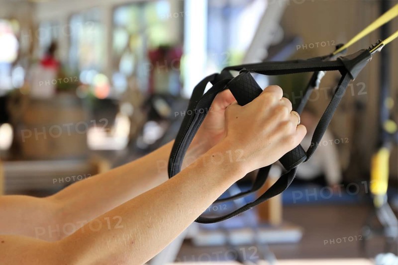 Young woman doing TRX training in the gym, (Neuhofen, Rhineland-Palatinate)