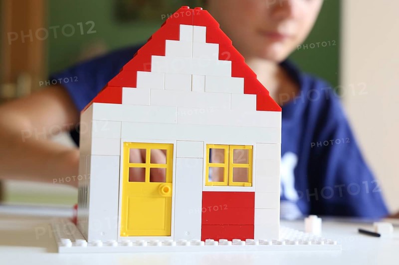 Symbolic image: Boy builds a house with building blocks