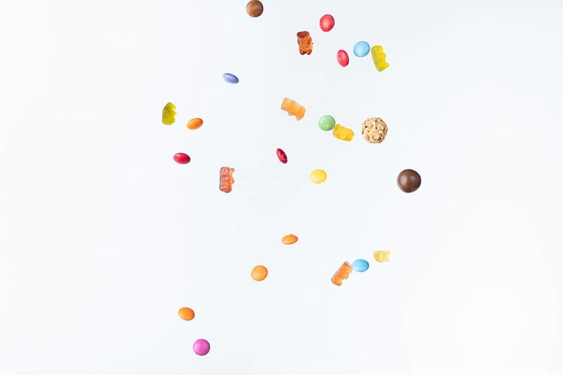Colourful sweets fall against a white background