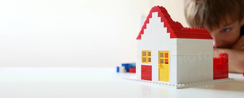 Boy builds a house with building blocks (with free space for text)