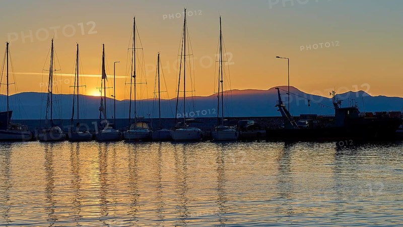 Yachts in the harbour at sunset with mountains in the background and evening sky, Gythio, Mani, Peloponnese, Greece, Europe