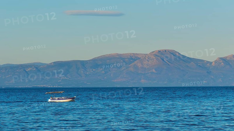 Lonely boat on the wide blue sea with mountains in the background and clear sky, Gythio, Mani, Peloponnese, Greece, Europe