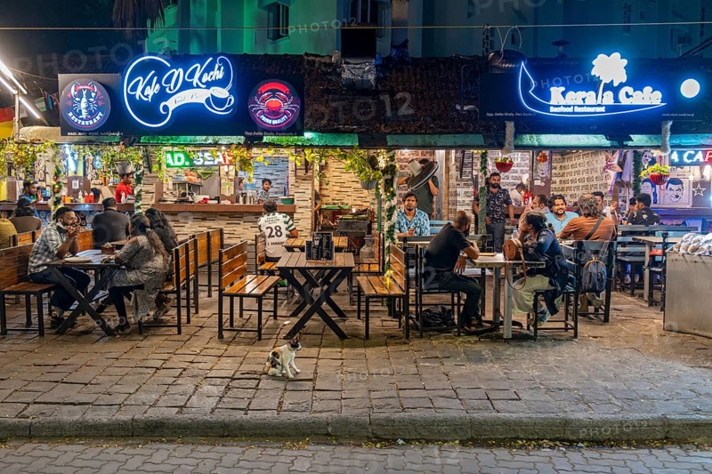 Diners enjoy a lively evening at a street-side restaurant on Tower Road, Fort Kochi, Cochin, Kerala, India, Asia