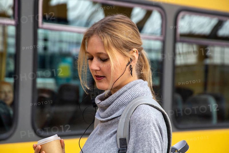 Close-up of a young woman in front of a train at the station