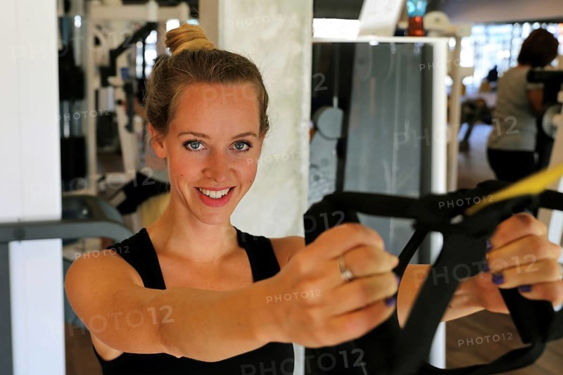 Young woman doing TRX training in the gym, (Neuhofen, Rhineland-Palatinate)