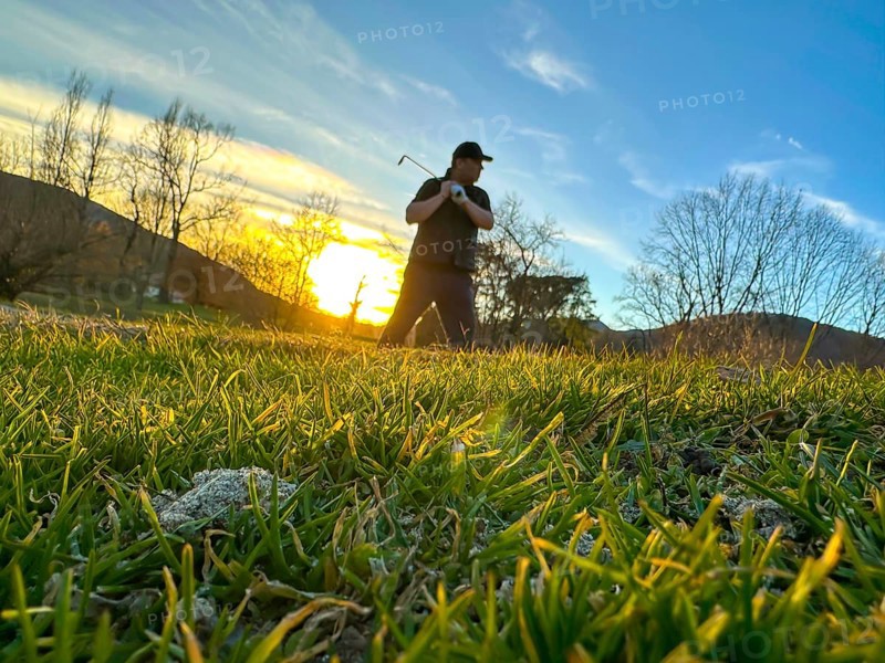 Golfer in a Sand Trap on Golf Course in Sunset in a Sunny Day in Switzerland