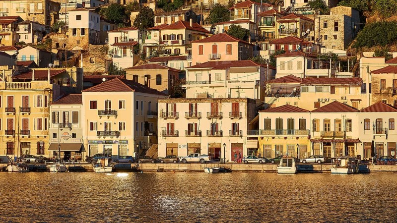 Houses and boats on the coast in the golden light of early morning, Gythio, Mani, Peloponnese, Greece, Europe
