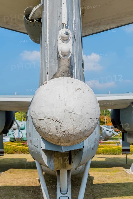 Rear view of ventrally-mounted retractable radar boom on military airplane in public park